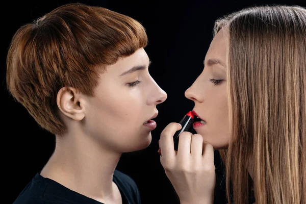 Woman applying lipstick onto girlfriend — Stock Photo