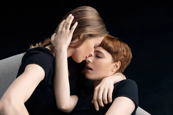 Lesbian couple embracing on couch — Stock Photo