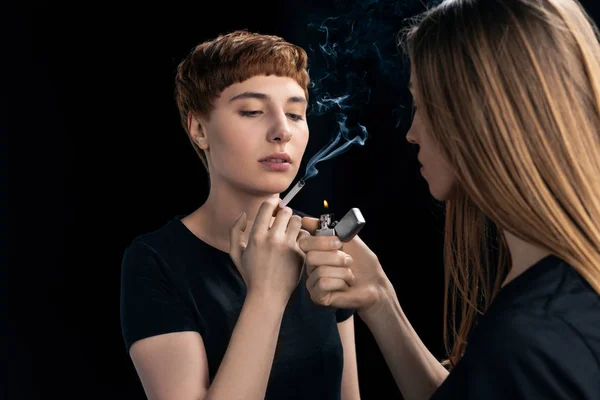 Mujer joven encendiendo cigarrillo - foto de stock