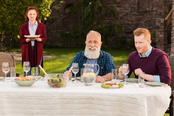 Glückliche Männer sitzen am Tisch — Stockfoto