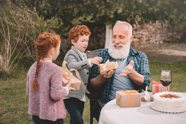 Kinder grüßen Großvater bei Geburtstagsfeier — Stockfoto