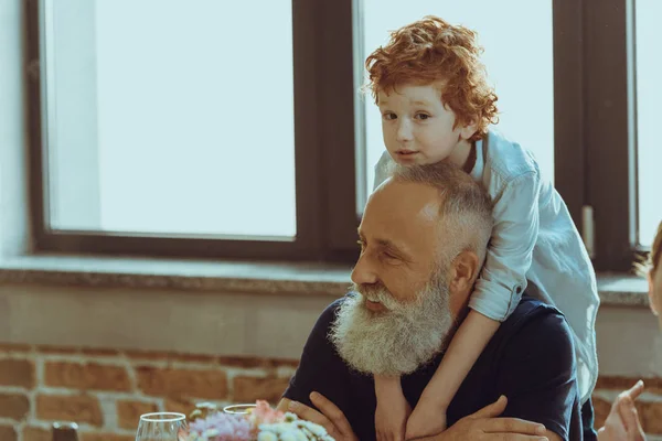 Niño abrazando abuelo - foto de stock