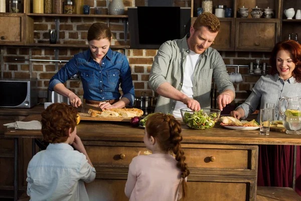 Familie bereitet Abendessen zu Hause zu — Stockfoto