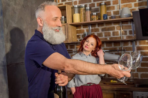 Senior man with wine glasses and bottle — Stock Photo