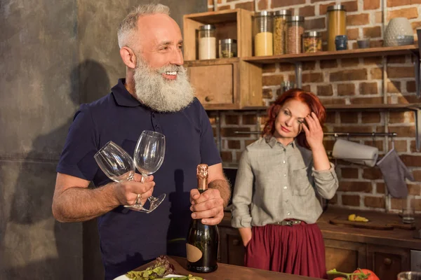 Senior man with wine glasses and bottle — Stock Photo