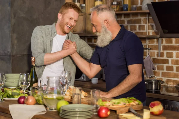 Father and son arm wrestling together — Stock Photo