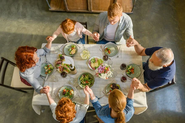 Priant en famille pendant le dîner — Photo de stock