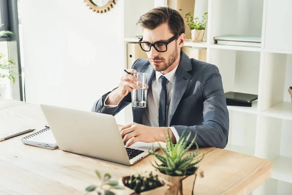 Бизнесмен работает с ноутбуком в офисе — стоковое фото