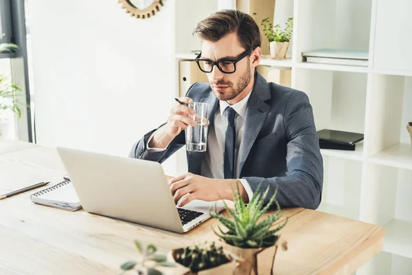 Hombre de negocios trabajando con el ordenador portátil en la oficina - foto de stock