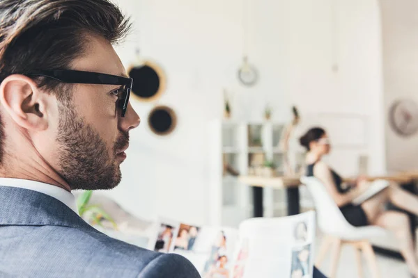 Young businessman sitting in office — Stock Photo