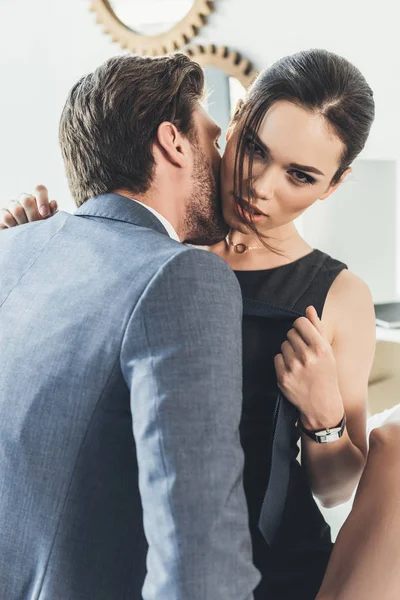 Hombre joven besándose mujer en el cuello - foto de stock