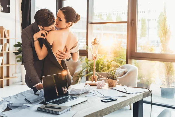 Молодая пара целуется в офисе — стоковое фото
