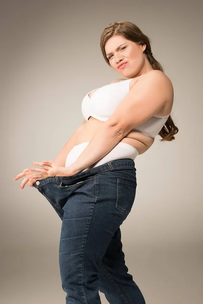 Femme en surpoids arrosage jeans — Photo de stock