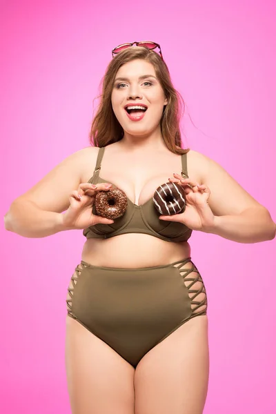 Alegre chica con sobrepeso con donas - foto de stock