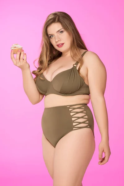 Mulher com sobrepeso segurando cupcake — Fotografia de Stock