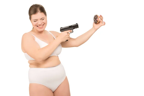 Overweight woman with gun and donut — Stock Photo