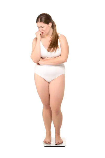 Upset overweight woman on scales — Stock Photo