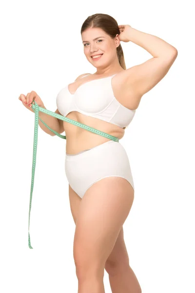 Mujer con sobrepeso que mide la cintura - foto de stock