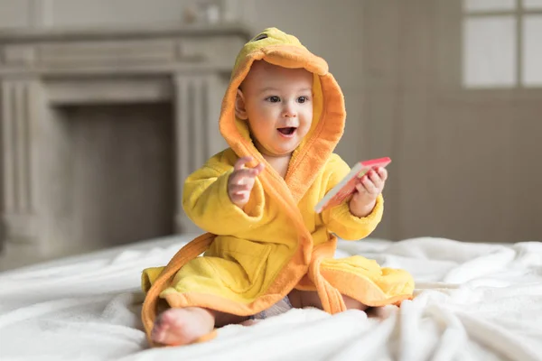 Bebé niño en bata amarilla Fotos de stock