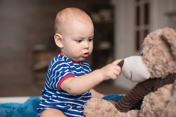 Мальчик играет с плюшевым мишкой — стоковое фото