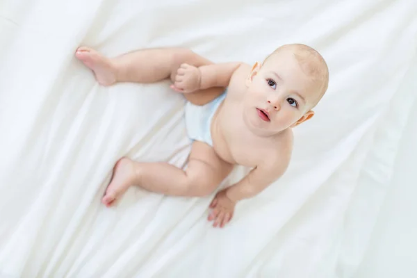 Baby boy sitting on bed — Stock Photo, Image