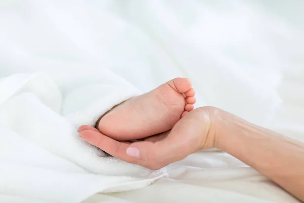 Madre sosteniendo el pie del niño — Foto de Stock