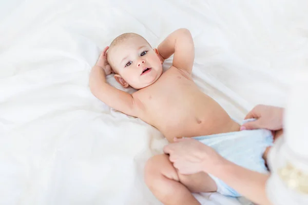 Mother changing diaper of baby boy — Stock Photo, Image