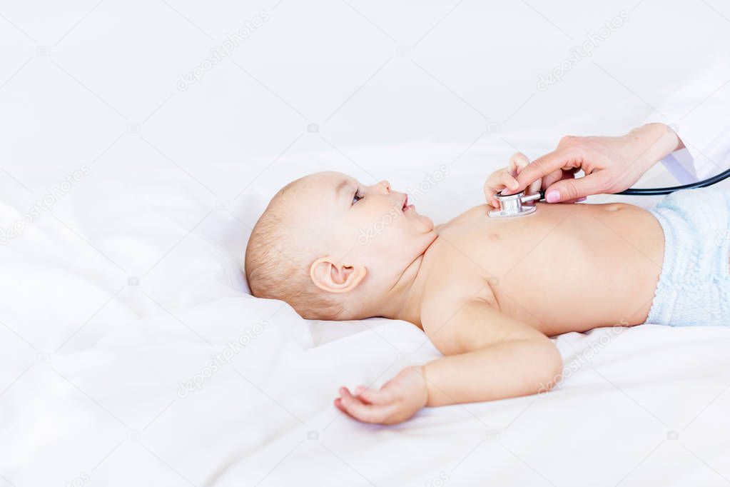 doctor examining baby boy with stethoscope