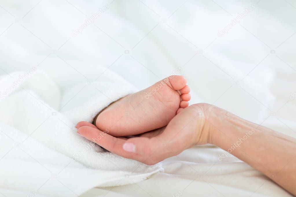 Mother holding foot of child 