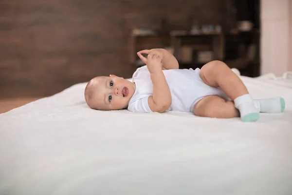 Mignon bébé garçon sur lit — Photo de stock