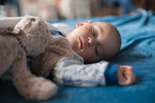 Boy sleeping with teddy bear — Stock Photo