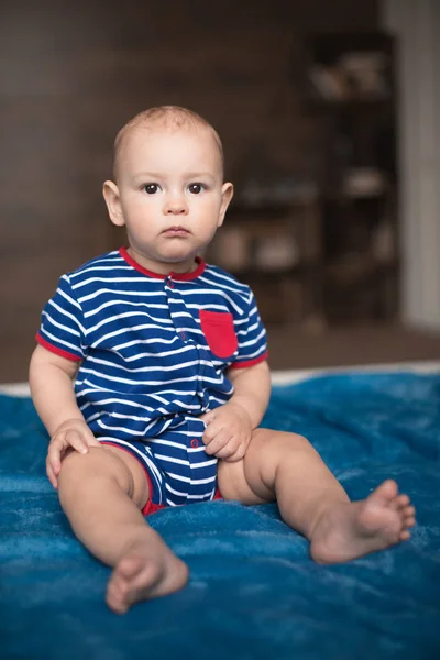 Mignon bébé garçon assis sur lit — Photo de stock