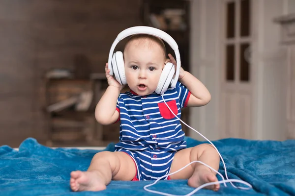 Baby boy wearing white headphones — Stock Photo