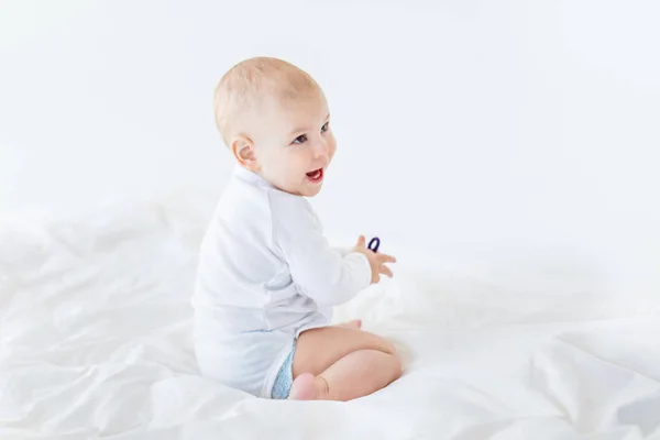 Baby boy sitting on bed — Stock Photo