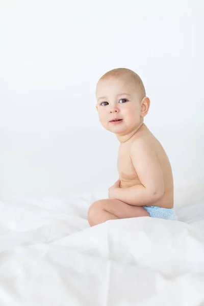 Baby boy sitting on bed — Stock Photo