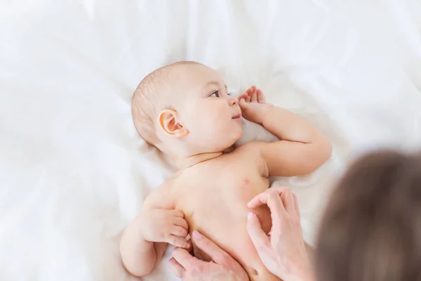 Mother massaging baby — Stock Photo