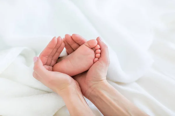 Mother holding foot of child — Stock Photo
