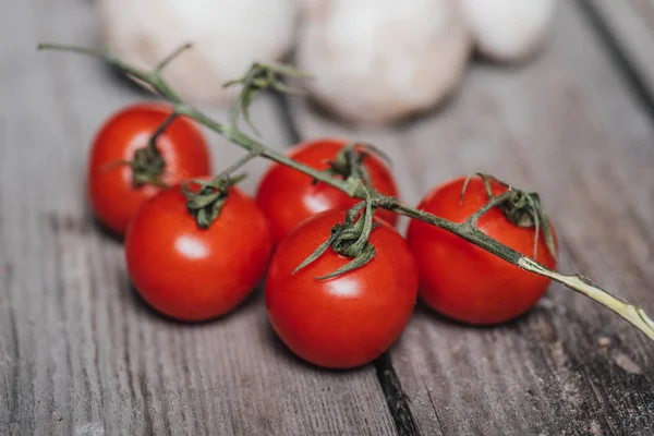 Cherry tomatoes with mushrooms on wooden table — Stock Photo, Image