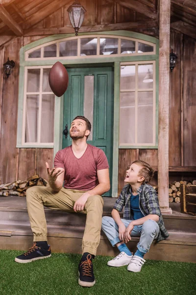 Отец с сыном играют с мячом на заднем дворе — стоковое фото