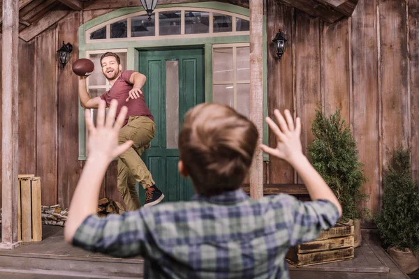 Vader en zoon spelen met de bal op de achtertuin — Stockfoto