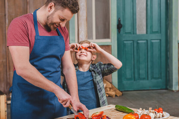 Отец и сын режут овощи
 