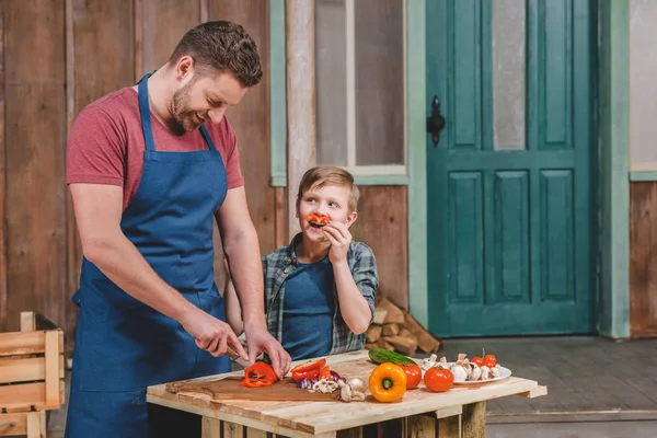 Padre e hijo cortando verduras —  Fotos de Stock