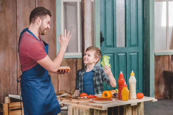 Baba ve oğul sosis pişirme — Stok fotoğraf