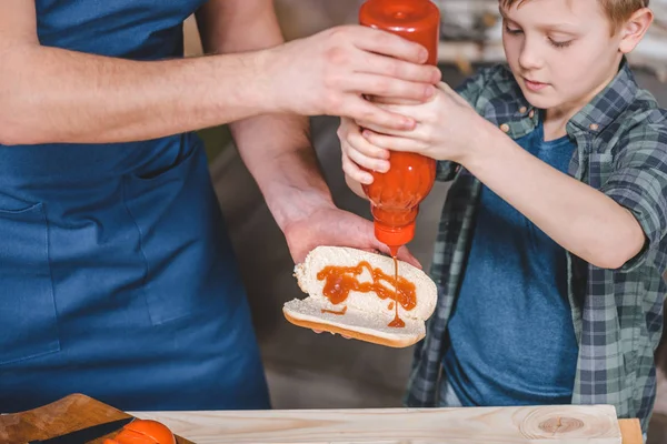 Padre e figlio che cucinano hot dog — Foto Stock