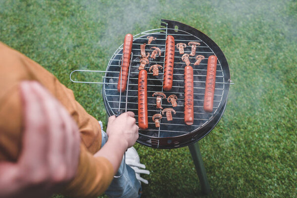 boy cooking hot dog sausages