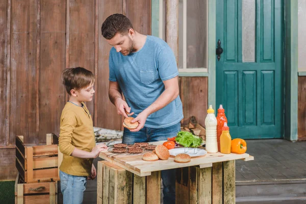 Apa és fia főzés hamburgert — Stock Fotó