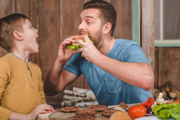 Homme mangeant un hamburger — Photo