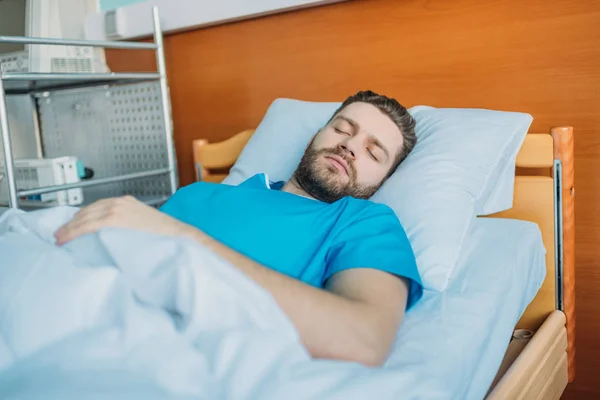 Chory człowiek śpi na łóżku szpitalnym — Zdjęcie stockowe