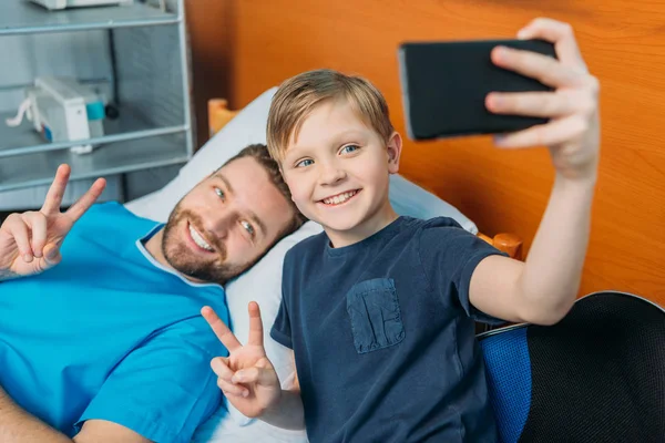 Pai e filho tomando selfie na enfermaria — Fotografia de Stock