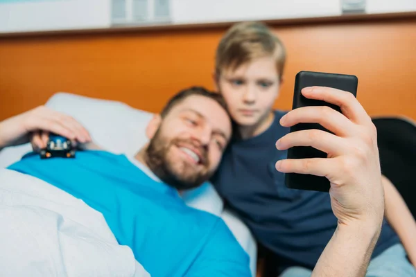 Padre e hijo tomando selfie en sala —  Fotos de Stock